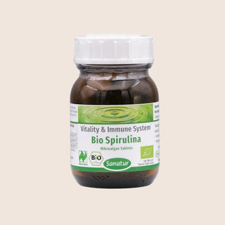Bottle of Bio Spirulina tablets with a white cap on a beige background