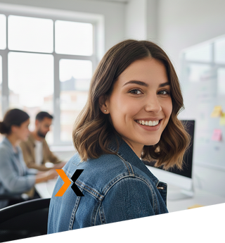 Woman smiling in an office setting with blurred colleagues in the background