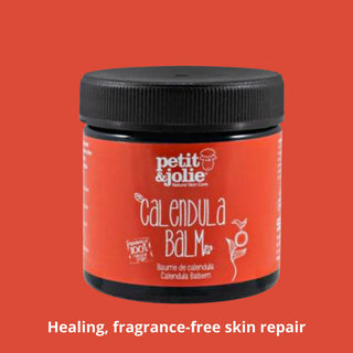 Jar of calendula balm with 'petit & jolie' branding on an orange background