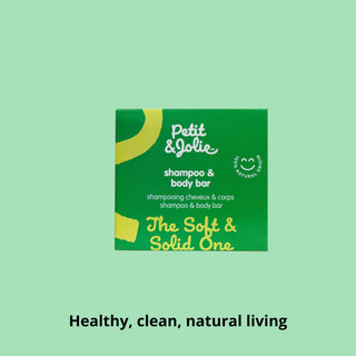 Petit Jolie shampoo and body bar packaging on a green background