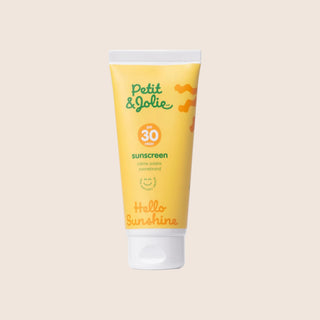 Petit & Jolie sunscreen tube on a beige background